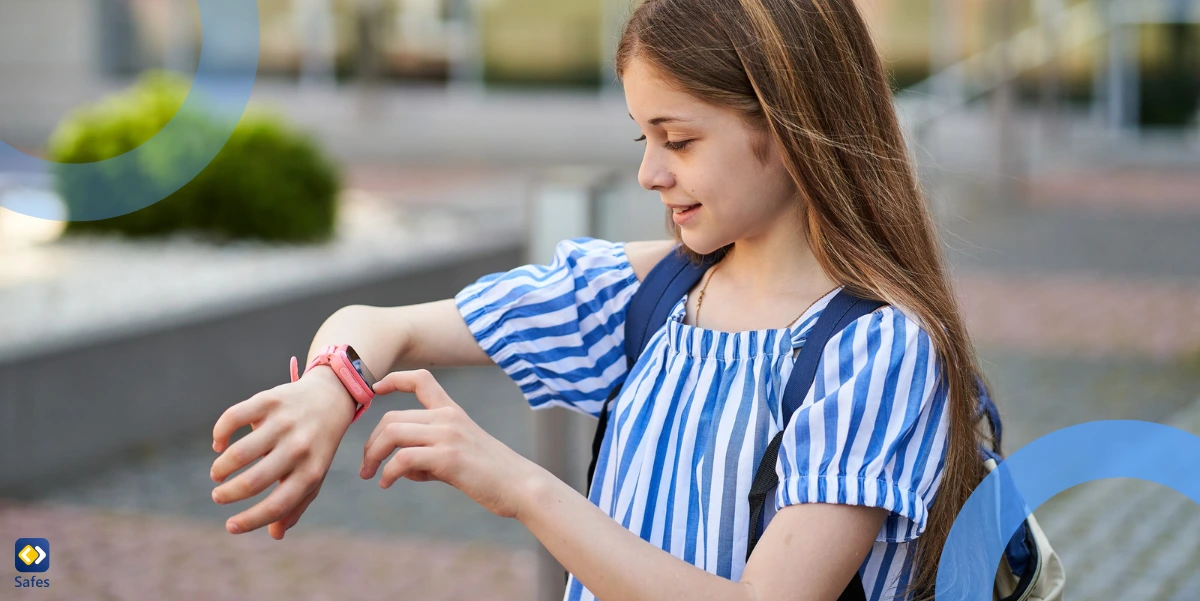 Glückliches junges Mädchen, das seine Eltern mit seiner rosa Smartwatch auf dem Schulgelände anruft