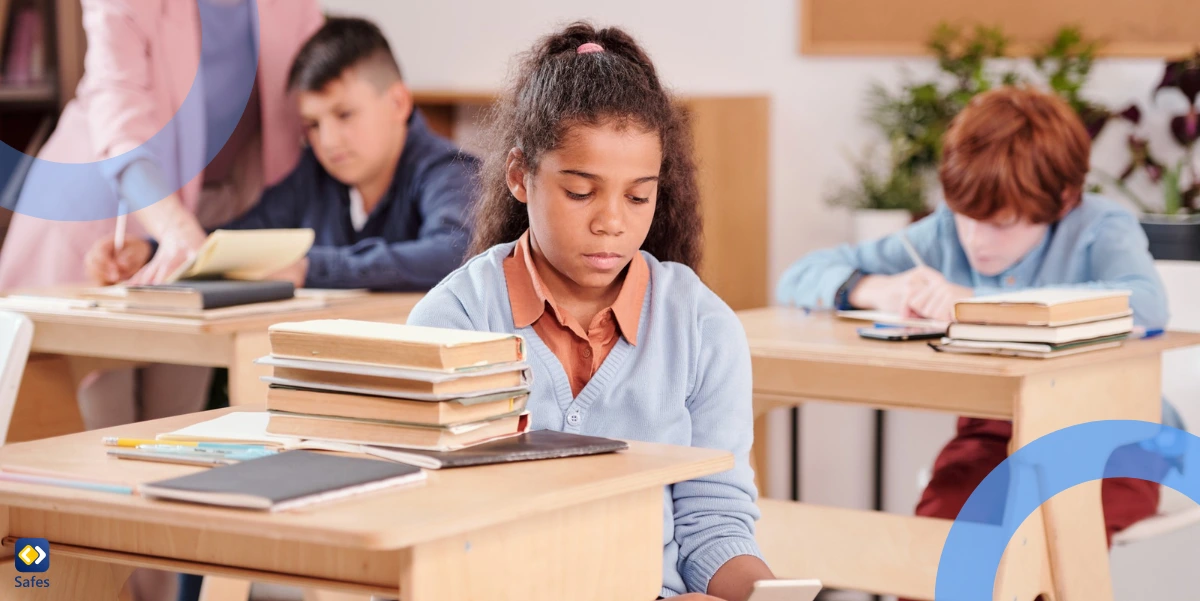 Schulmädchen benutzt Smartphone und versteckt es, während der Lehrer einem anderen Schüler hilft